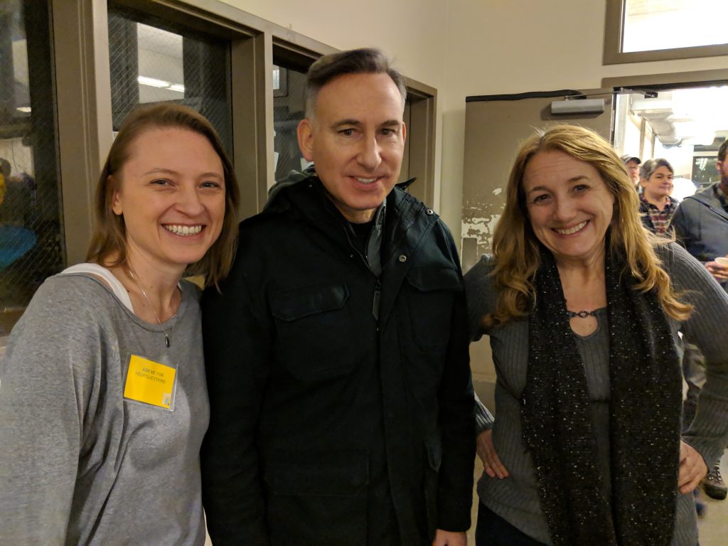 Three people stand together smiling