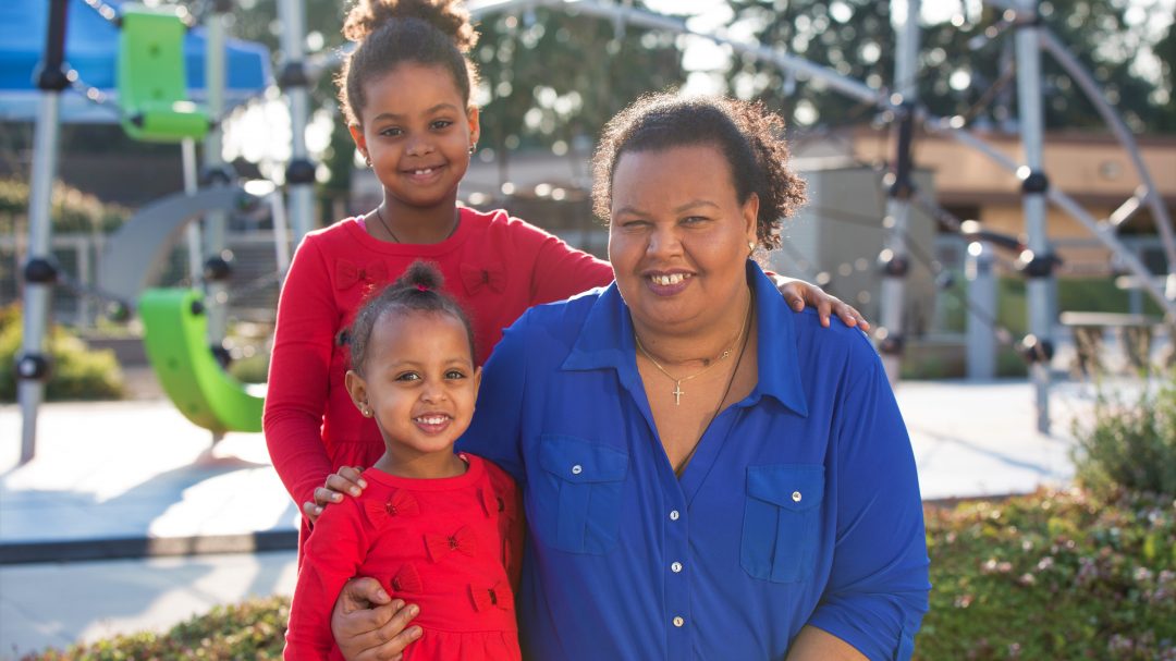 Smiling mom with two daughters