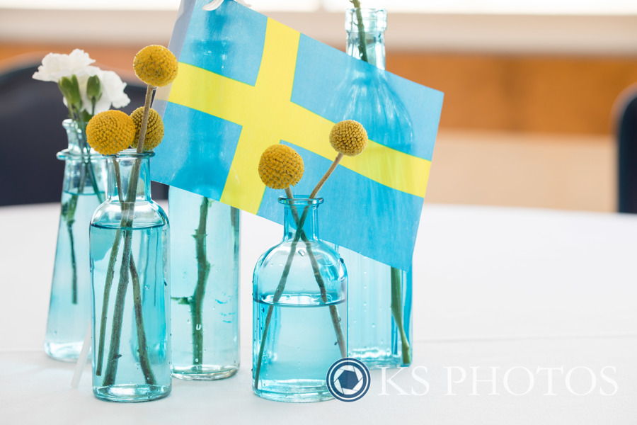 Flowers inside light blue vases near the Swedish flag